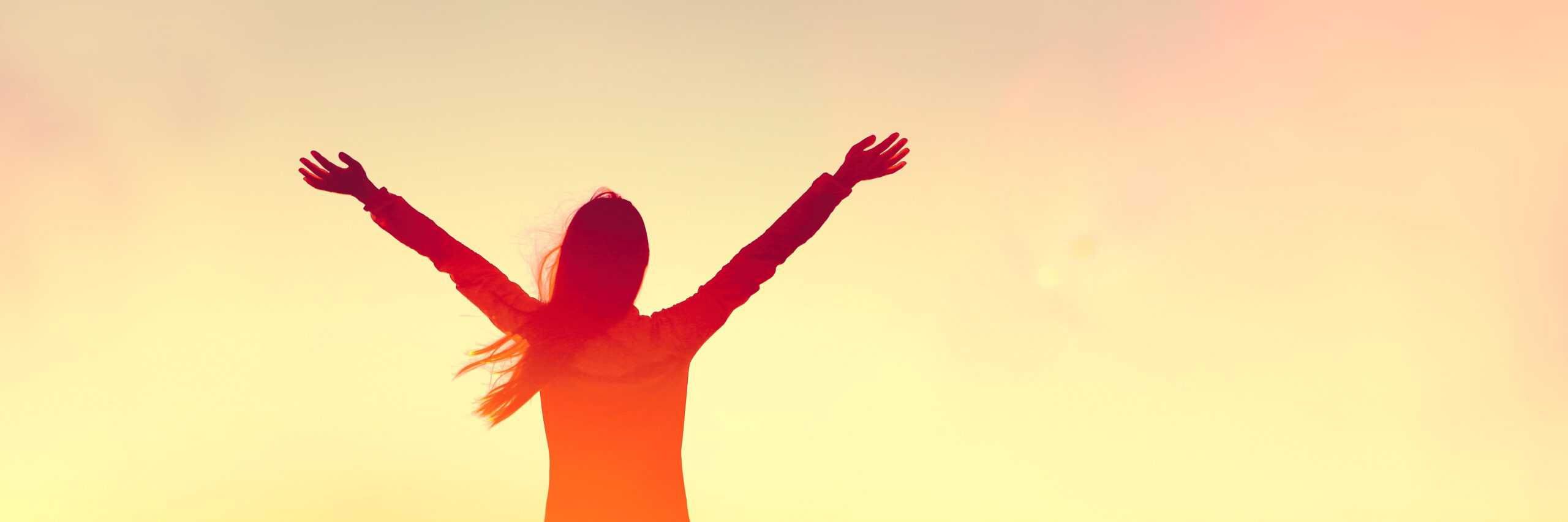 woman with arms outstretched celebrating her recovery