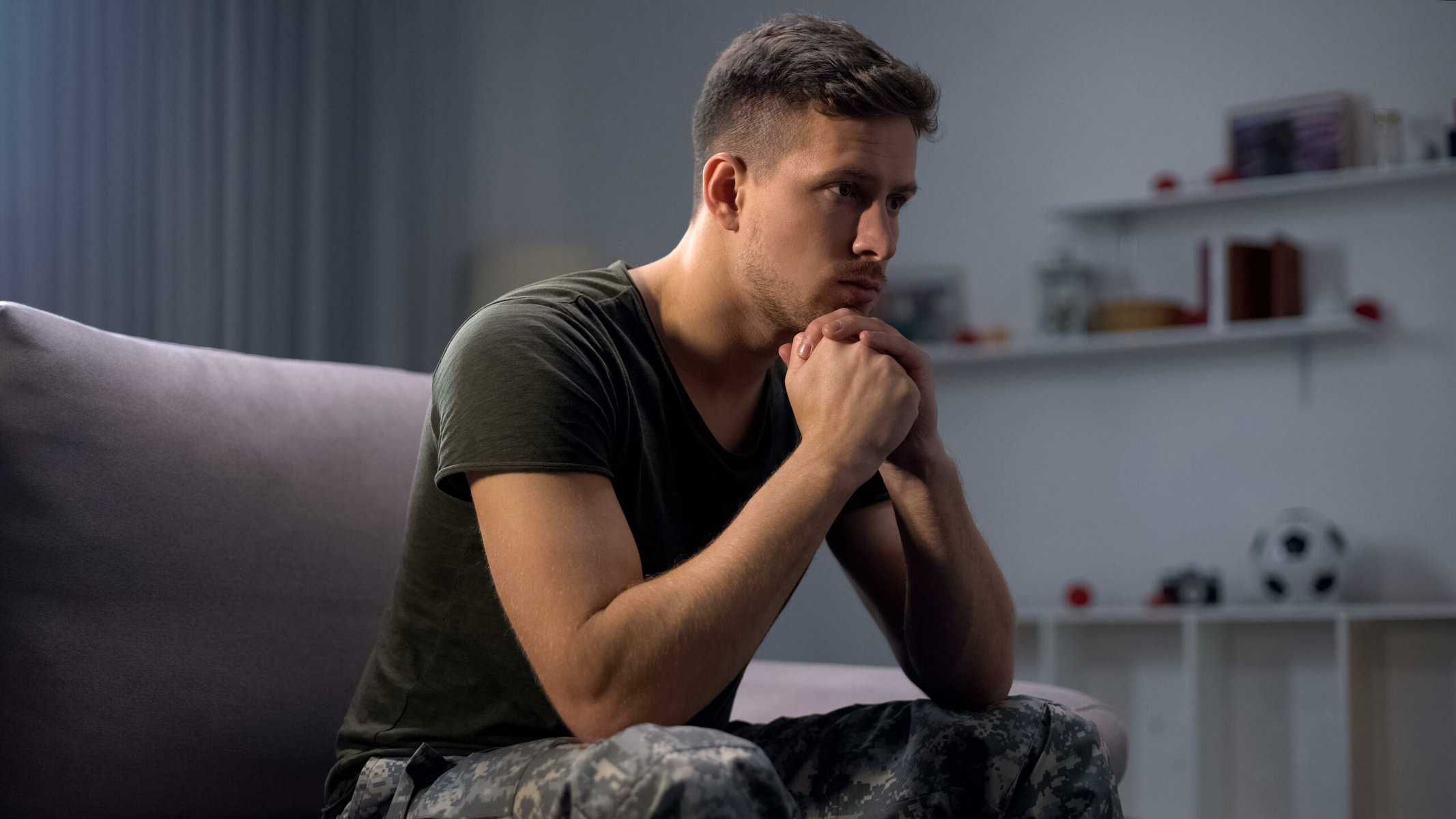 veteran with PTSD sitting on a couch feeling upset
