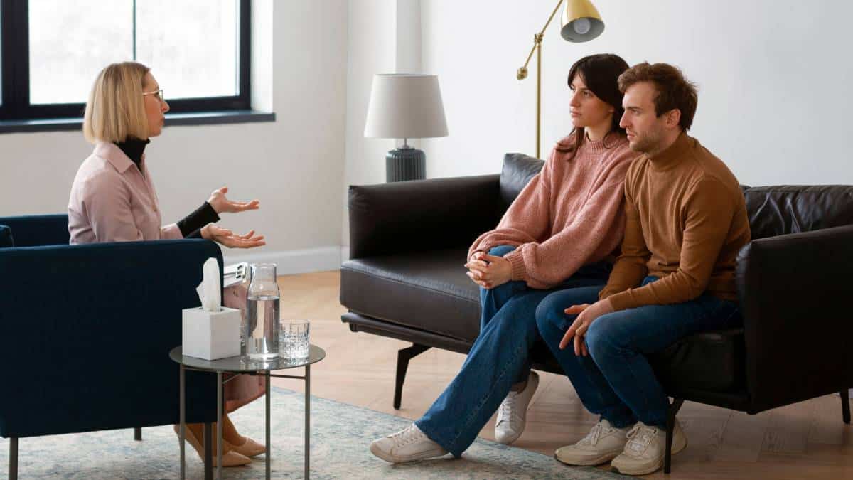 Couple during a family therapy session discussing addiction treatment and topics like "my husband's drinking is ruining our marriage".